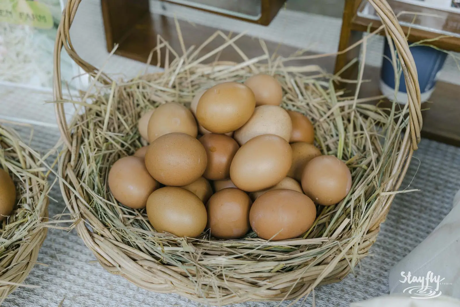 Basket of brown eggs in straw nest.