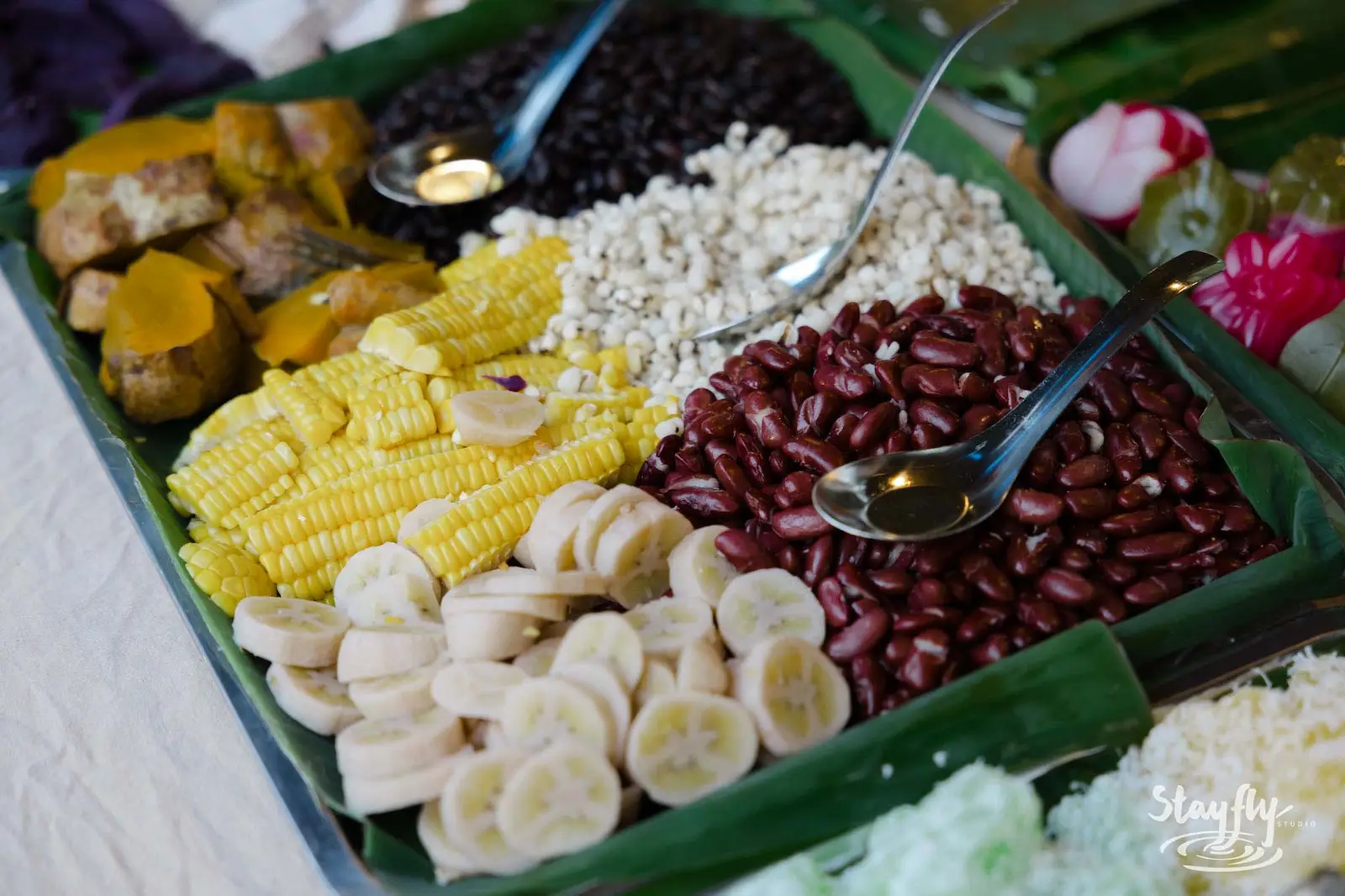 Banana leaf platter of beans corn and bananas.