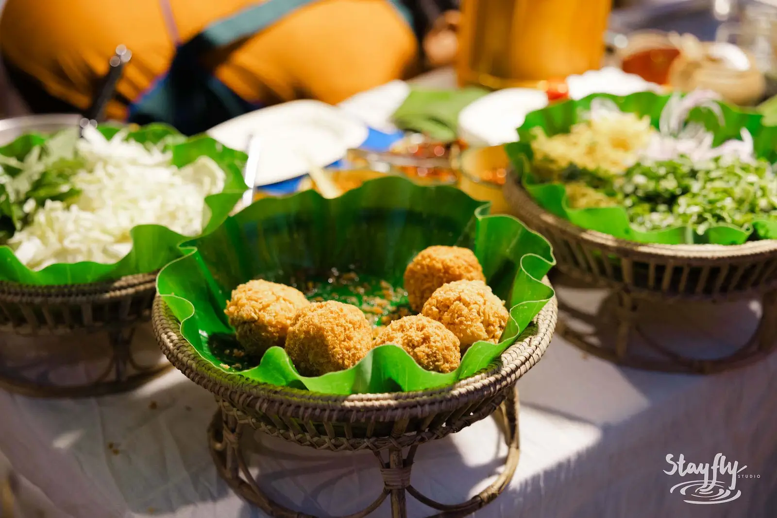 Fried snacks served on banana leaf trays.