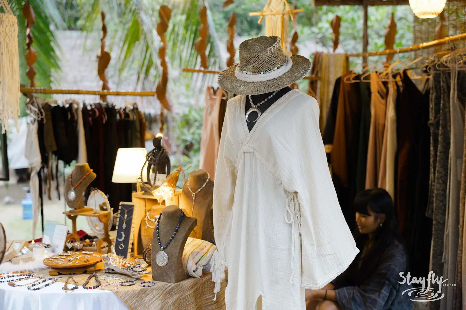 Clothing and jewelry displayed on mannequin at market.