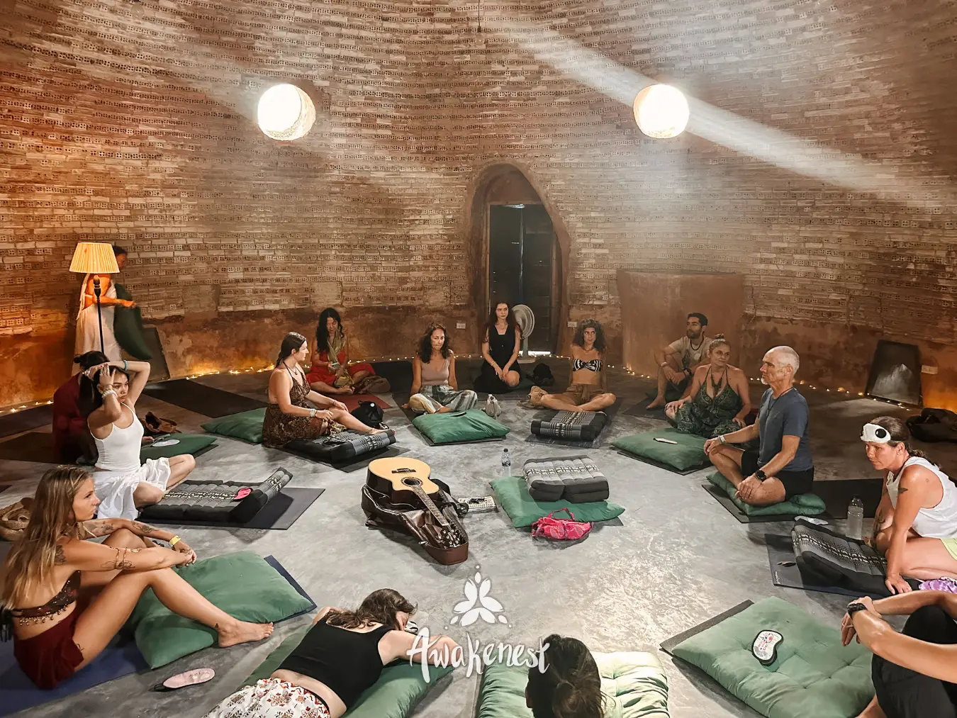 Circle seated inside domed brick chamber with guitar.